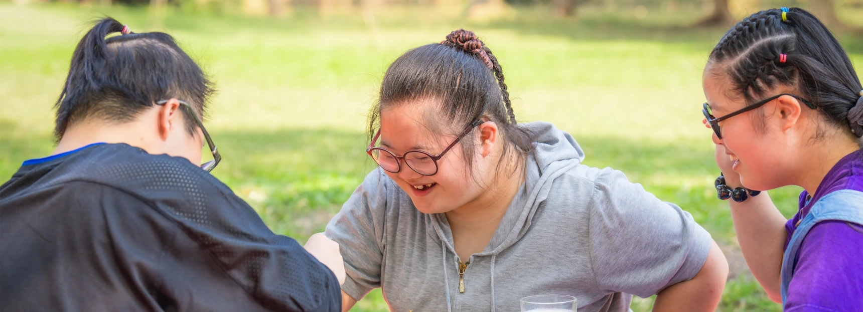 Group of friends with down syndrome having fun playing chess board together outdoor in park