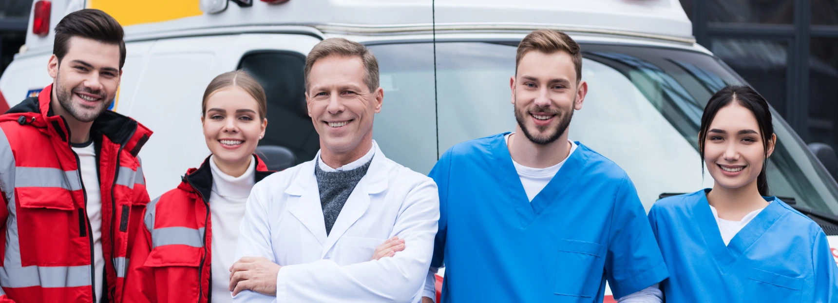 Happy ambulance doctors working team standing in front of car